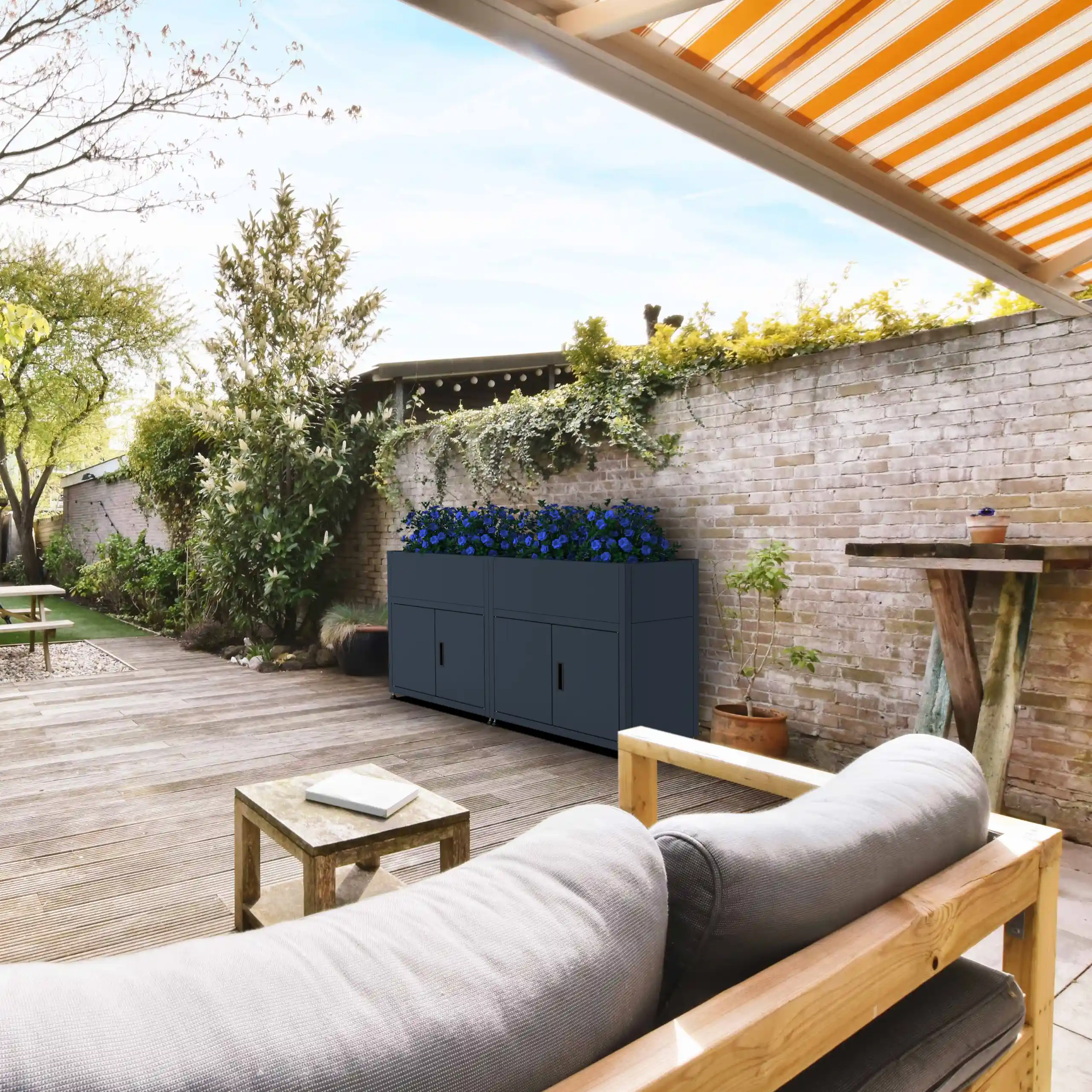 Bepflanztes Hochbeet mit Unterschrank als stilvoller Raumteiler auf einer modernen Terrasse.