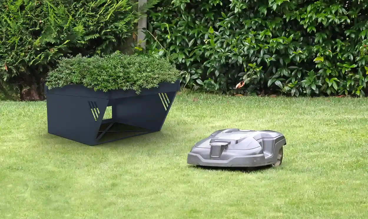 Hochbeet für Mähroboter in Anthrazit, bepflanzt im Garten neben einem Mähroboter